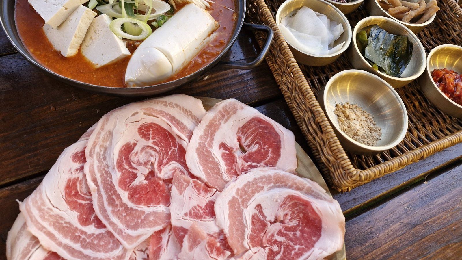 놋쇠 접시에 둥글게 만 얇은 생삼겹살과 전골, 놋그릇 반찬 바구니